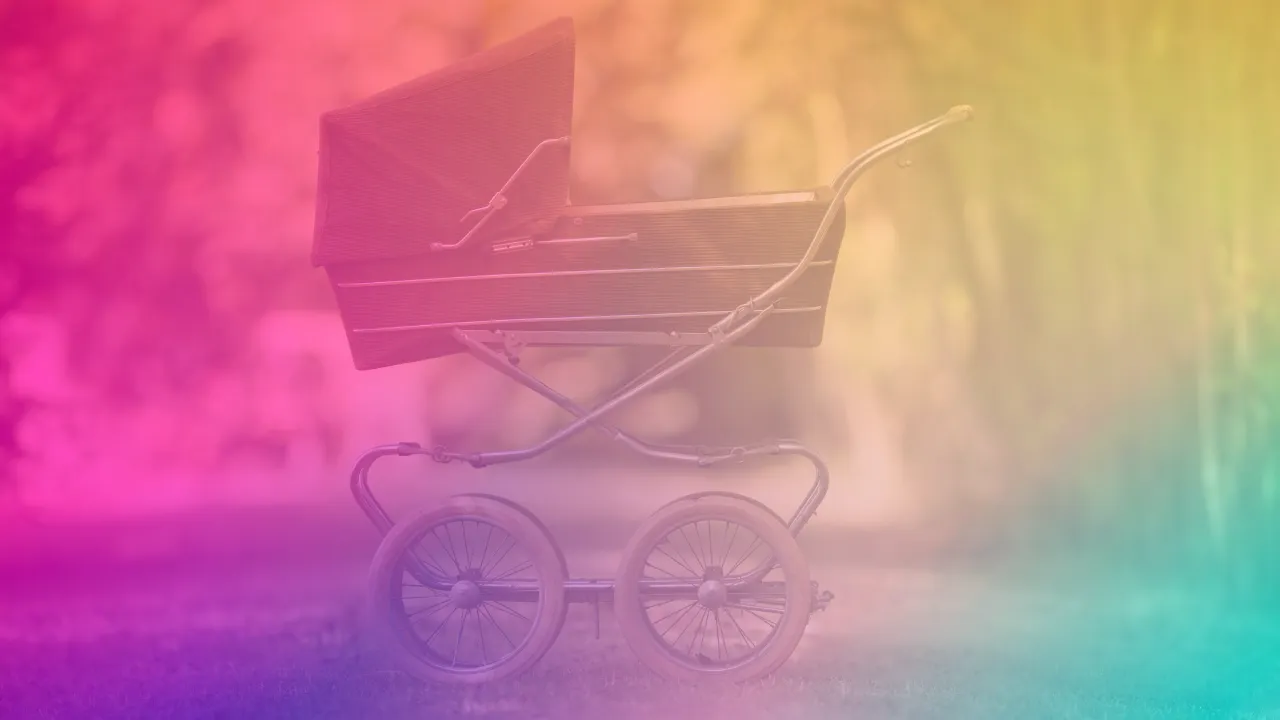 A woman in soft focus, mid-thought, standing outdoors with her baby in a wrap