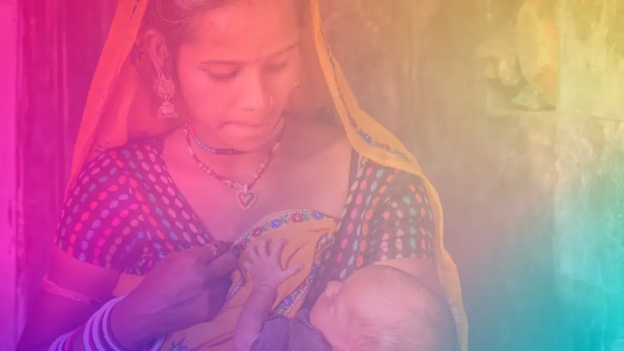 A quiet interior scene of a new mother sitting with her baby by a window